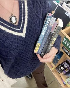 a woman holding several books in her hands