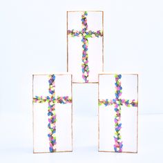 four small square frames with colorful beads on the edges and a cross in the middle