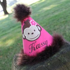 a pink hat with a monkey on it and the word sasy written in black