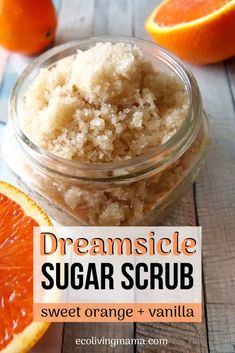 an orange and vanilla sugar scrub in a glass jar next to sliced oranges on a wooden table