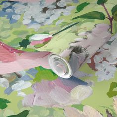 a wallpaper with pink and green flowers on the side, next to a roll of tape