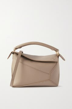 Jonathan Anderson released Loewe's 'Puzzle' bag in 2015 and it remains one of the house's best-selling styles because it still looks so fresh. This mini version has been hand-finished in Spain from textured-leather and has lacquered tonal edges. It can be worn and carried in a few different ways - including as a clutch or backpack. Loewe Puzzle Bag Small Outfit, Loewe Hobo Puzzle Bag, Mini Loewe Puzzle Bag, Loewe Puzzle Shoulder Bag, Loewe Small Puzzle Bag, Loewe Puzzle Bag, Loewe Puzzle, Tas Bahu, Puzzle Bag