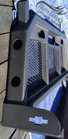 the front end of a gray truck with holes in it