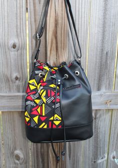 This is a great casual bucket bag made with marine vinyl and beautiful African Print Fabric. It can be worn as a crossbody bag or as a shoulder bag. Measurement: 13 inches height x 14 inches wide x 11 x 6 inches wide oval bottom Features 1 Zipper pocket on the outside of the bag 2 Slip Pockets inside 1 Zipper pocket inside Adjustable straps Please contact me if you have any questions about this bag. This bag is made to order and the lining ( inside) will be black. Please visit my shop at: http:/ School Shoulder Bucket Bag With Detachable Strap, School Bucket Shoulder Bag With Adjustable Strap, Casual Bucket Bag With Detachable Strap For School, School Crossbody Bucket Bag With Detachable Strap, School Bucket Bag With Detachable Crossbody Strap, Crossbody Bucket Bag With Detachable Strap For School, School Satchel With Detachable Strap And Bucket Shape, Everyday Crossbody Drawstring Bag With Adjustable Strap, Casual Bucket Bag Backpack With Detachable Strap