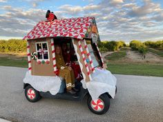 a person sitting in a vehicle made to look like a house with candy canes on the roof