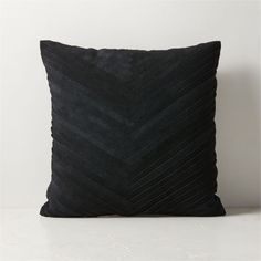 a black pillow sitting on top of a white table