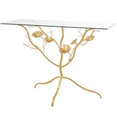 a glass table with gold leaves and branches on the top, against a white background