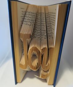 an open book with the word love made out of folded books on top of it