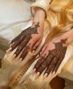 two hands with henna tattoos on them