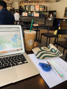 an open laptop computer sitting on top of a table next to a cup of coffee