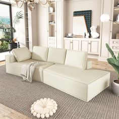 a white couch sitting on top of a rug in a living room next to a potted plant