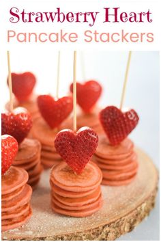 heart shaped strawberries are on top of pancakes with toothpicks in the shape of hearts