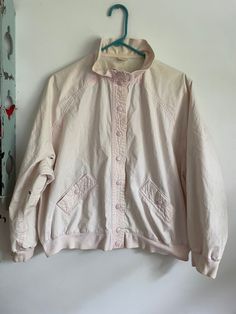 Cute vintage 1980s/90s, Jantzen 100% cotton, pale pink bomber jacket. Snap closures, knit cuffs, hem, and mock neck collar, and Raglan sleeves.  Tagged size large and measures 29 inches pit to pit and 23 inches long.  Overall great vintage condition with three light stains found. Save last three photos for details. Casual Pink Outerwear For Daywear, Oversized Pink Outerwear For Daywear, Pink Oversized Outerwear For Daywear, Vintage Cotton Outerwear With Stand Collar, Oversized Pink Cotton Outerwear, Vintage Pink Spring Outerwear, Retro Pink Windbreaker, Vintage White Cotton Windbreaker, 90s Pink Spring Windbreaker