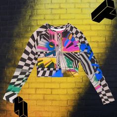 "Introducing the ultimate must-have for your wardrobe - our Checkered Aesthetic Surf Shirt! Whether you're hitting the gym, the beach, or dancing at your favorite music festival, this long sleeve crop top is guaranteed to turn heads. Featuring a mesmerizing abstract geometric pattern inspired by science and street art, this psychedelic shirt is not only trendy but also environmentally friendly, as it's made from recycled polyester and elastane. With a UPF 50+ rating, you can stay cool and protected from the sun's harmful rays during hot summer months. The double-layered waistline band ensures a comfortable and secure fit, making it perfect for sports and workouts, while the raglan sleeves add a touch of sophistication to your style. But that's not all - this festival top also has a tear-aw Checkered Aesthetic, Edm Music Festivals, Dance Crop Tops, Festival Dance, Festival Shirt, Edm Music, Surf Shirt, Long Sleeve Workout, Festival Shirts