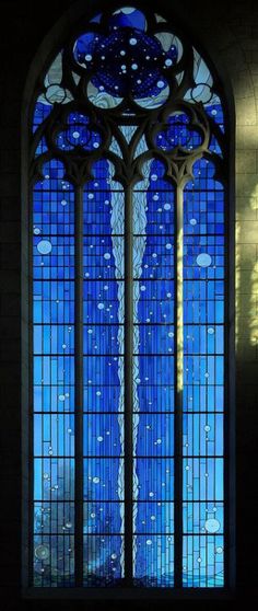 a large stained glass window in the side of a building with blue and white paint