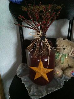 a teddy bear sitting on top of a chair next to a jar with a star