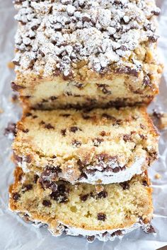 three pieces of cake sitting on top of foil covered in powdered sugar and chocolate chips