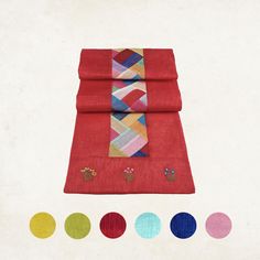 three pieces of red cloth with different colored designs on them and four colors of circles around the edges