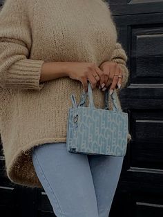 a woman is holding a blue purse