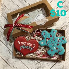 two decorated cookies in a box with the words i love you to pieces