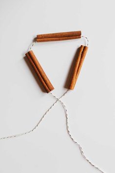 cinnamon sticks are tied up with twine on a white surface, ready to be used as an ornament