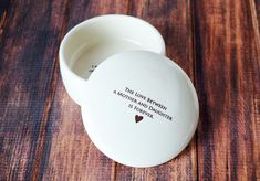 a small white bowl sitting on top of a wooden table