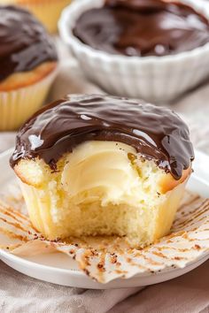 two cupcakes with chocolate frosting on a plate