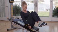 a woman sitting on top of a bench in a gym