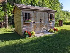 a small wooden shed sitting on top of a lush green field