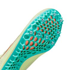 the sole of a woman's shoe with spikes on it and blue and orange