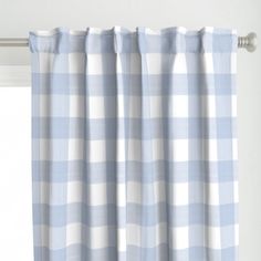 a blue and white checkered curtain hanging in front of a window