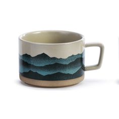 two mugs with mountains painted on them sitting side by side in front of each other