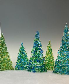 three small trees made out of colored paper