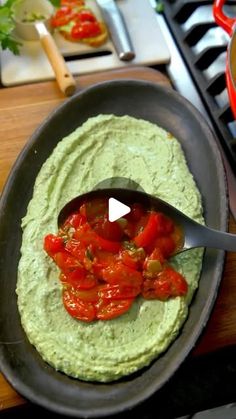 a pan filled with guacamole and tomatoes