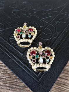 This listing is for the set of two vintage crown pins. These are beautiful, and covered in rhinestones and pearls. There are ruby red stones, opals, green, amber, pink, and pearls. The metal is gold tone. Each pin is 1 1/2 in. long, and 1 1/4 in. wide. Both are in great vintage condition. Thank you Regency Costume, Patriotic Jewelry, Holiday Necklace, Vintage Crown, Vintage Lockets, Mid Century Jewelry, Mid Century Mod, Gold Charm Bracelet, Photo Locket