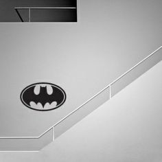 a black and white photo of a batman symbol on the ceiling in an office building