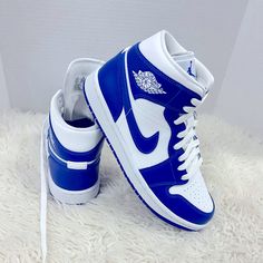 Jordan Brand Is Added A Brand New Colorway Of Their Air Jordan 1 Mid That Comes Dressed In A White And Hyper Royal Color Scheme. This Air Jordan 1 Features A White Tumbled Leather Upper Paired With Hyper Royal Blue Smooth Leather Overlay. Perforated Detailing On The Toe Box, Wings Logo On The Ankle And Jumpman Branding On The Tongues And Insole. Finishing Off The Design Is A White Midsole With A Blue Rubber Outsole. Jordans Nike Air, Blue High Top Nikes, Blue And White Air Jordans, Jordan 1 Bleu, Royal Blue Nike Shoes, Custom High-top Sneakers With Branded Heel, White Sole High-top Jordan Shoes With Branded Heel Counter, Womens Jordans Sneakers, Jordan 1 Blue And White