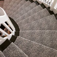 a spiral staircase with black and white patterned carpet