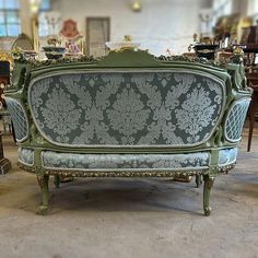 an antique couch is sitting in the middle of a room