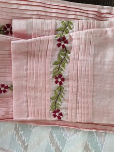 three pieces of pink fabric with red and green flowers on them, sitting next to each other