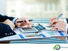 three business people working on paperwork with calculator, pen and laptop in front of them