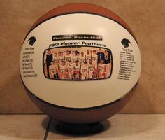 an old fashioned basketball with the team's name on it is displayed in front of a wall