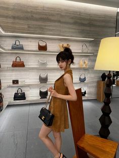 a woman standing in front of a display of handbags