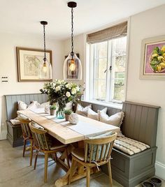 a dining room table and bench with flowers in vases on the centerpiece next to it