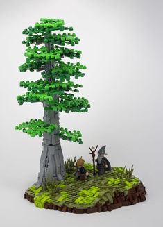 a lego model of a tree with two people standing next to it