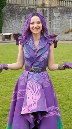 a woman with purple hair is standing in the grass wearing gloves and a dress that has an animal print on it