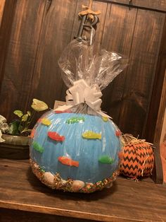 a decorative pumpkin with fish on it sitting on a table