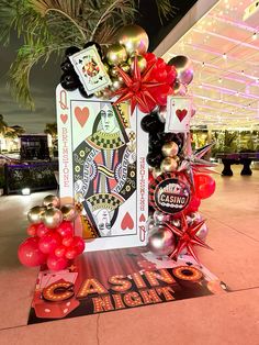 a casino themed table with balloons and cards on it for an event in las vegas, nv