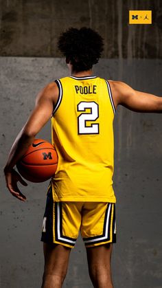 a basketball player in yellow jersey holding a ball