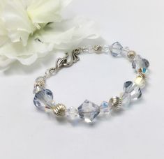 Swarovski Crystal Bracelet, Beaded Bracelet, Sterling Silver Bracelet, Iridescent Bracelet, Bridal Jewelry, Pale Blue Crystal Bracelet  This is a really beautiful bracelet.  Great gift for your BFF!  Or maybe something new for yourself.  Beautiful pale blue bicone shaped Swarovski crystals are the focal point of this bracelet. The large icy blue crystals, sterling silver beads and clear iridescent crystals make for very clean lines. Finished with a beautiful hook and loop clasp.  Bright and beautiful!   Beads are 6 and 8 mm.   Fits nicely around a 6 1/2 to 7 inch wrist. If you like this one, you might also like this: https://etsy.me/2Cqj4Bb Blue Crystal Bracelet, Iridescent Crystal, Swarovski Crystal Bracelet, Jewelry Blue, Icy Blue, Bracelet Beaded, Rose Gold Bracelet, Bead Jewellery, Crystal Bracelet